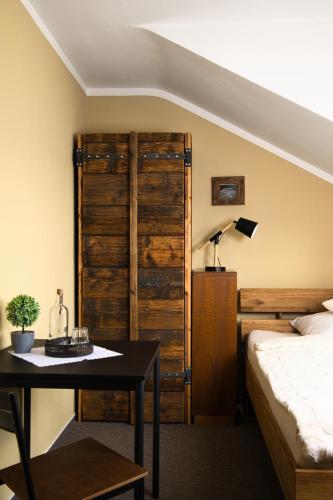 a bedroom with a bed and a table with a lamp at Hotel STARÝ MLÝN in Jeseník