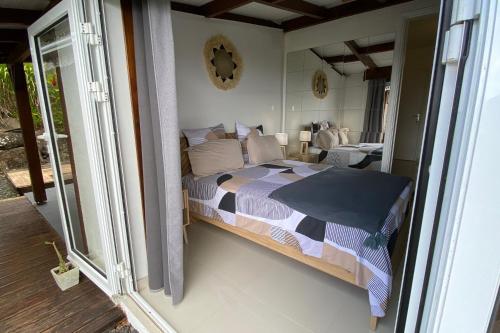 a bedroom with a bed and a balcony at Villa Le Nid des Colibris in Saint-Charles