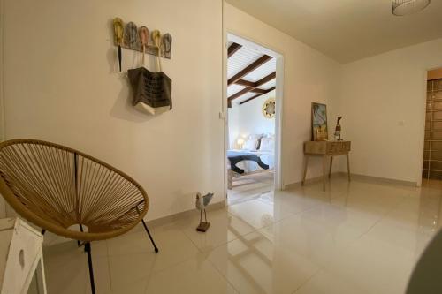 a living room with a chair and a table at Villa Le Nid des Colibris in Saint-Charles