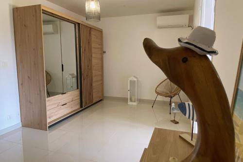 a room with a wooden bear wearing a hat at Villa Le Nid des Colibris in Saint-Charles