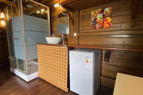 a small kitchen with a refrigerator and a counter at Villa Le Nid des Colibris in Saint-Charles