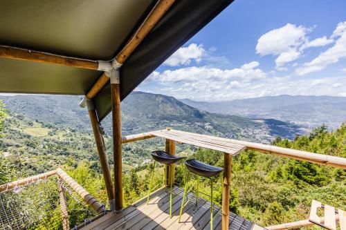 two chairs on a balcony with a view of mountains at Skyline Ecoliving Santa Elena in Santa Elena