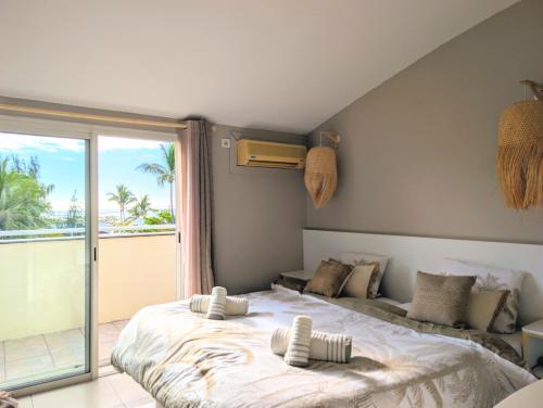 Saint-PaulにあるHorizon plage - 3 chambres et spaのベッドが2つと大きな窓がある寝室