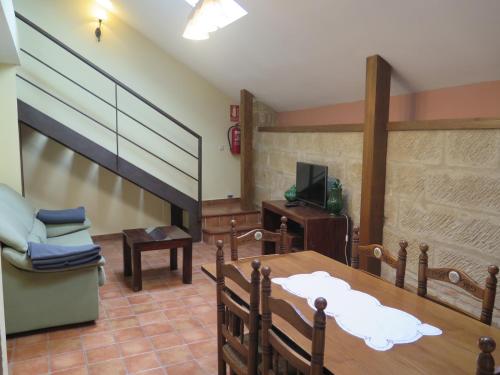 a dining room with a table and a couch and a television at La Casa del Seise in Baeza