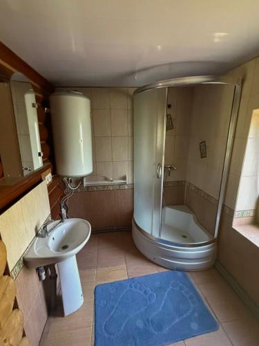 a bathroom with a shower and a sink and a tub at На Кружалі in Vorokhta
