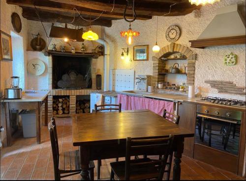 a large kitchen with a wooden table and chairs at Casa di Viola in Celleno