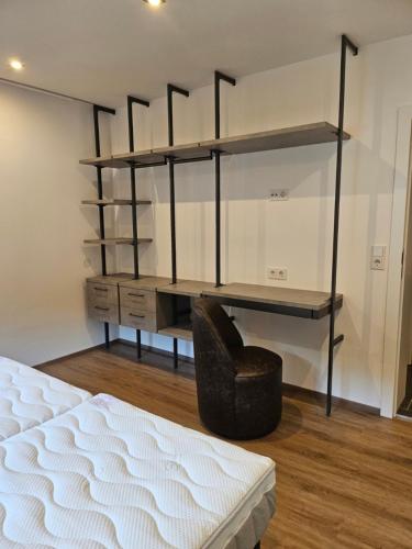 a bedroom with a bed and a desk and a chair at lechner living apartments in Wald im Pinzgau