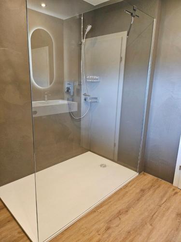 a shower with a glass door in a bathroom at lechner living apartments in Wald im Pinzgau