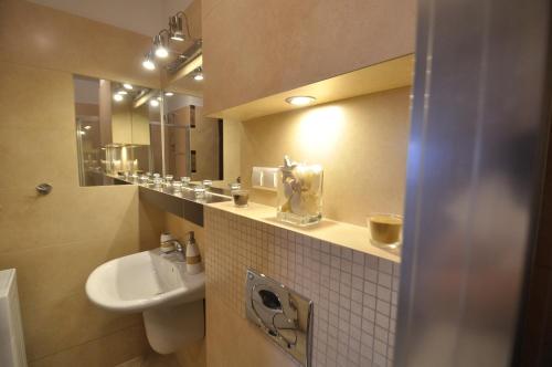 une salle de bain avec un lavabo, des toilettes et un miroir dans l'établissement Apartament Spokojny, à Kościelisko
