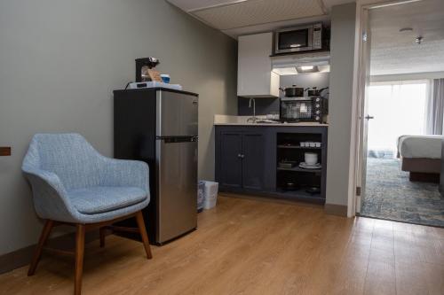 a kitchen with a chair and a refrigerator in a room at Four Points by Sheraton Suites Tampa Airport Westshore in Tampa