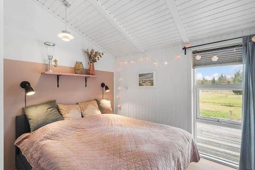 a bedroom with a large bed and a window at BL1074-Saltum-Solmarken-3 in Saltum
