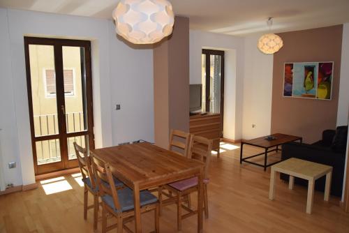 comedor y sala de estar con mesa y sillas en Apartamentos Zaragoza Coso, en Zaragoza