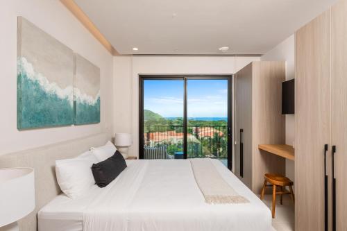 une chambre avec un lit blanc et une grande fenêtre dans l'établissement Kokito at Naumi, Ocean Views & Beach Club, à Coco