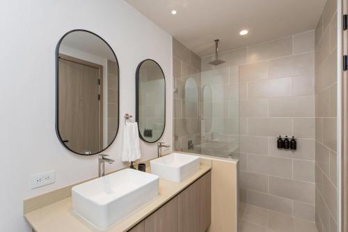 une salle de bain avec deux lavabos et un miroir dans l'établissement Kokito at Naumi, Ocean Views & Beach Club, à Coco