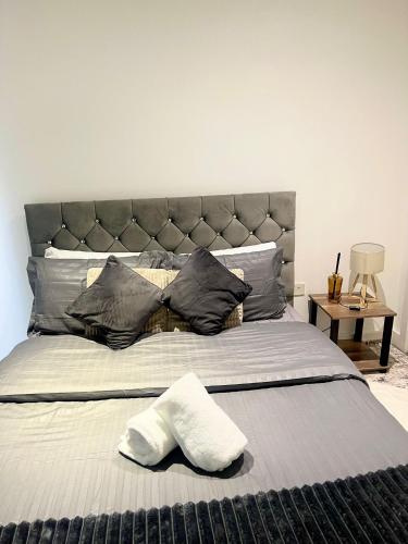 a bedroom with a large bed with a large headboard at Colindale Apartments in Colindale