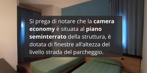 a room with two beds and a sign on the wall at Hotel I Cedri in Scandicci