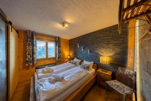 ein Schlafzimmer mit einem großen Bett an einer Holzwand in der Unterkunft Chalet Chanterelle - Cosy et montagnard in Plan Fey