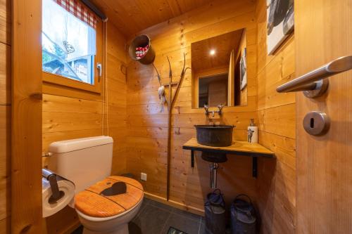 ein Holzbadezimmer mit einem WC und einem Waschbecken in der Unterkunft Chalet Chanterelle - Cosy et montagnard in Plan Fey