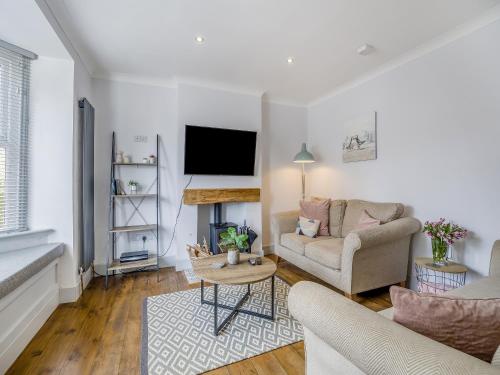 a living room with a couch and a tv at Florence Cottage in Heacham