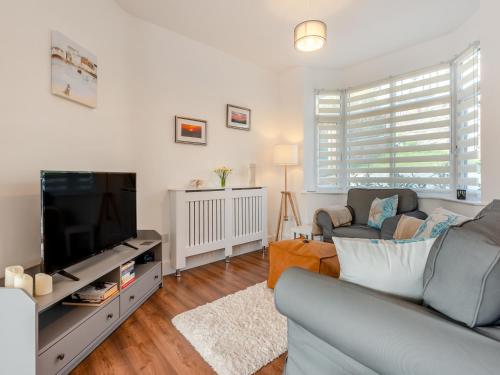 a living room with a couch and a tv at The Laurels in Goodwick