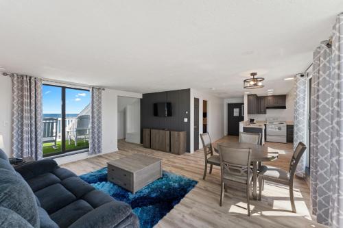 a living room and kitchen with a couch and a table at Pilgrim Sands on Long Beach in Plymouth