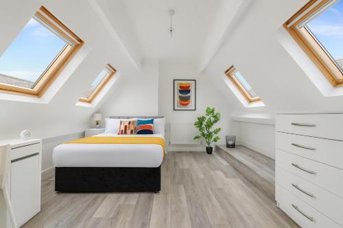 a white bedroom with a bed and skylights at Manygates House by Alt-Stay - Wakefield Budget Friendly Contractor and Relocation Accommodation - Private Room with Parking, Fast Wi Fi, In Room Tea and Coffee, Shared Kitchen, Bathrooms and Lounge - Long Stay Ready with Weekly and Monthly Rates in Wakefield