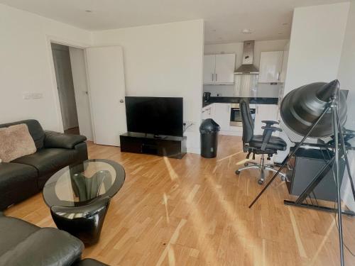 a living room with a couch and a flat screen tv at Colindale Apartments in Colindale