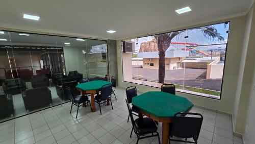 a classroom with two tables and chairs and a window at diRoma Villas direto com o Grupo diRoma com acesso ao Acqua Park e Café da manhã in Caldas Novas