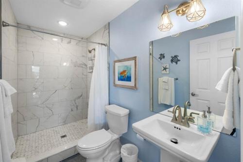 a bathroom with a toilet and a sink and a shower at Spacious Home With Heated Pool! Sleeps 15! Billiard table! in Hernando Beach
