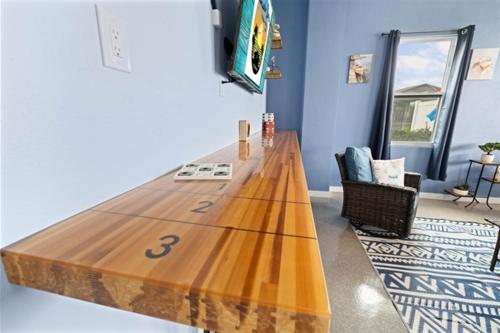 a large wooden surfboard on a table in a room at Spacious Home With Heated Pool! Sleeps 15! Billiard table! in Hernando Beach
