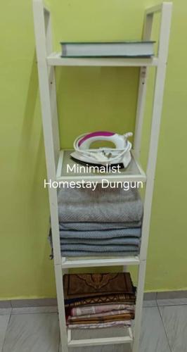 - une étagère avec des serviettes dans la chambre dans l'établissement Minimalist Homestay Dungun x1, à Kampong Sura Tengah