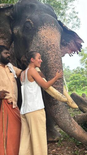 a woman is standing next to an elephant at Coconut Bay Marari in Mararikulam