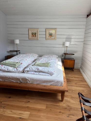 a bed in a room with two lamps and two tables at Bäckdalens Bed and Breakfast & Café in Båstad