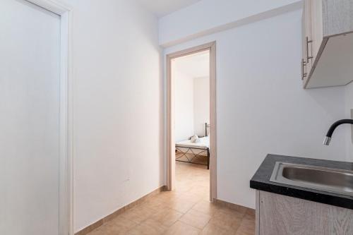a kitchen with a sink and a door to a room at Gavriil Apartment G2 in Corfu