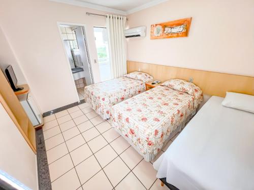 a small room with two beds and a window at diRoma Villas direto com o Grupo diRoma com acesso ao Acqua Park e Café da manhã in Caldas Novas