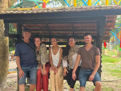 a group of people posing for a picture in front of a playground at Coconut Bay Marari in Mararikulam