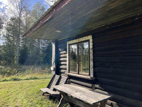 a wooden bench sitting outside of a log cabin at Pangamäe puhkemaja in Lokuta