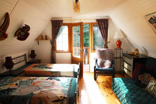a attic room with a bed and a couch at Chata Wiedźmy - Sanktuarium Laparica w Puszczy Białej 