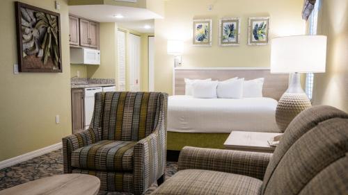 a hotel room with a bed and two chairs at Holiday Inn Club Vacations Cape Canaveral Beach Resort in Cape Canaveral