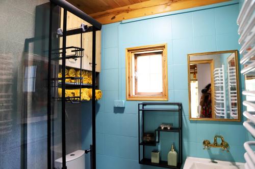 a bathroom with blue walls and a sink and a mirror at Chata Wiedźmy - Sanktuarium Laparica w Puszczy Białej 