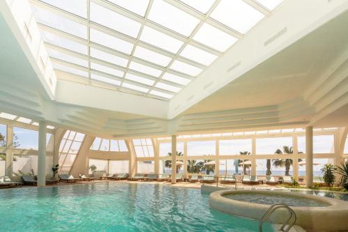 a swimming pool in a hotel with a glass ceiling at Royal Azur Thalassa in Hammamet