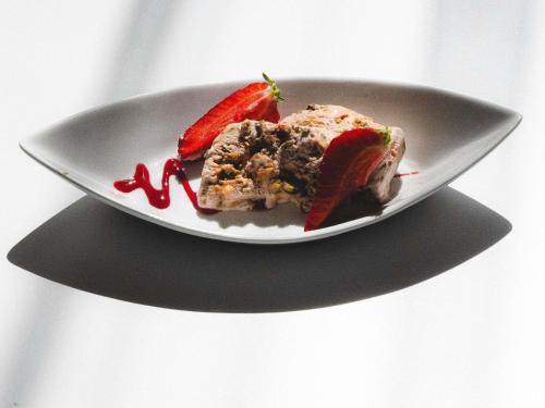 a plate with a piece of cake and a strawberry at Mercure Nantes Centre Grand Hotel in Nantes