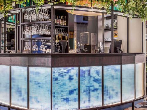 a bar with a view of a swimming pool at ibis Styles Evry Courcouronnes Hotel and Events in Evry-Courcouronnes