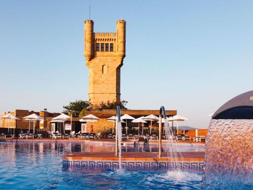 a water fountain in front of a building with a tower at Mercure Monte Igueldo in Donostia-San Sebastián