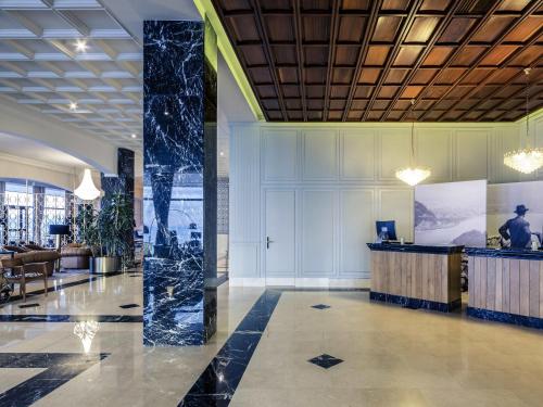 a lobby with a pillar in the middle of a building at Mercure Monte Igueldo in Donostia-San Sebastián