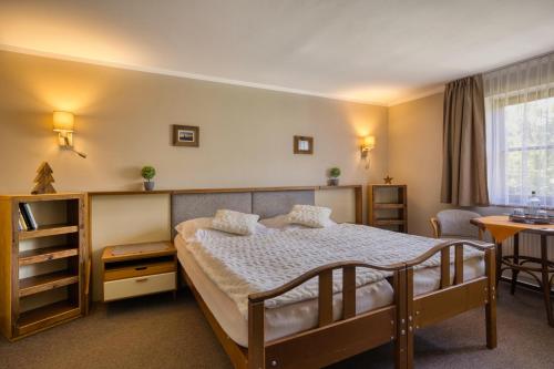 a bedroom with a bed and a table and chairs at Hotel STARÝ MLÝN in Jeseník