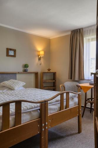 a bedroom with a bed and a chair and a window at Hotel STARÝ MLÝN in Jeseník