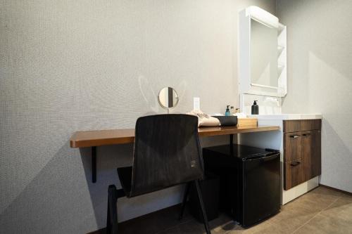 a desk with a mirror and a chair in a bathroom at UNZIPPER KUMAMOTO - Private Sauna Stay - in Kumamoto