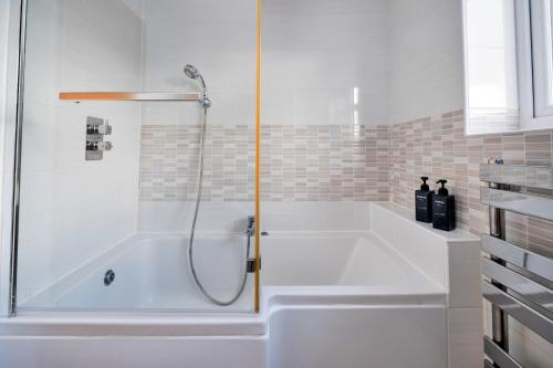 a bath tub with a shower in a bathroom at Finest Retreats - Elizabeth House in Kington