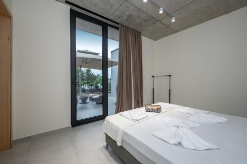 a bedroom with a white bed and a large window at 5 Star Apartment in Villa Magnetica in Shekvetili
